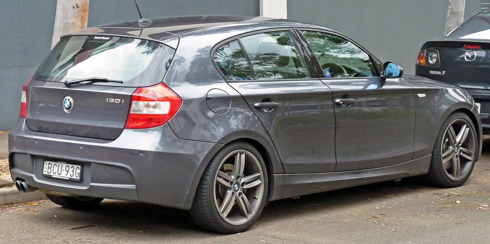 Grey BMW 130i Sport five-door, rear three-quarter view