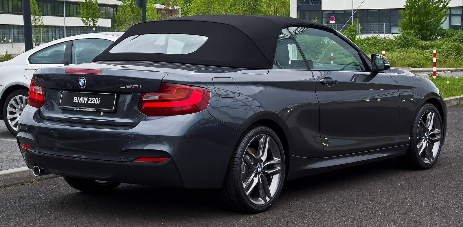 Grey BMW 220i M Sport convertible, rear three-quarter view