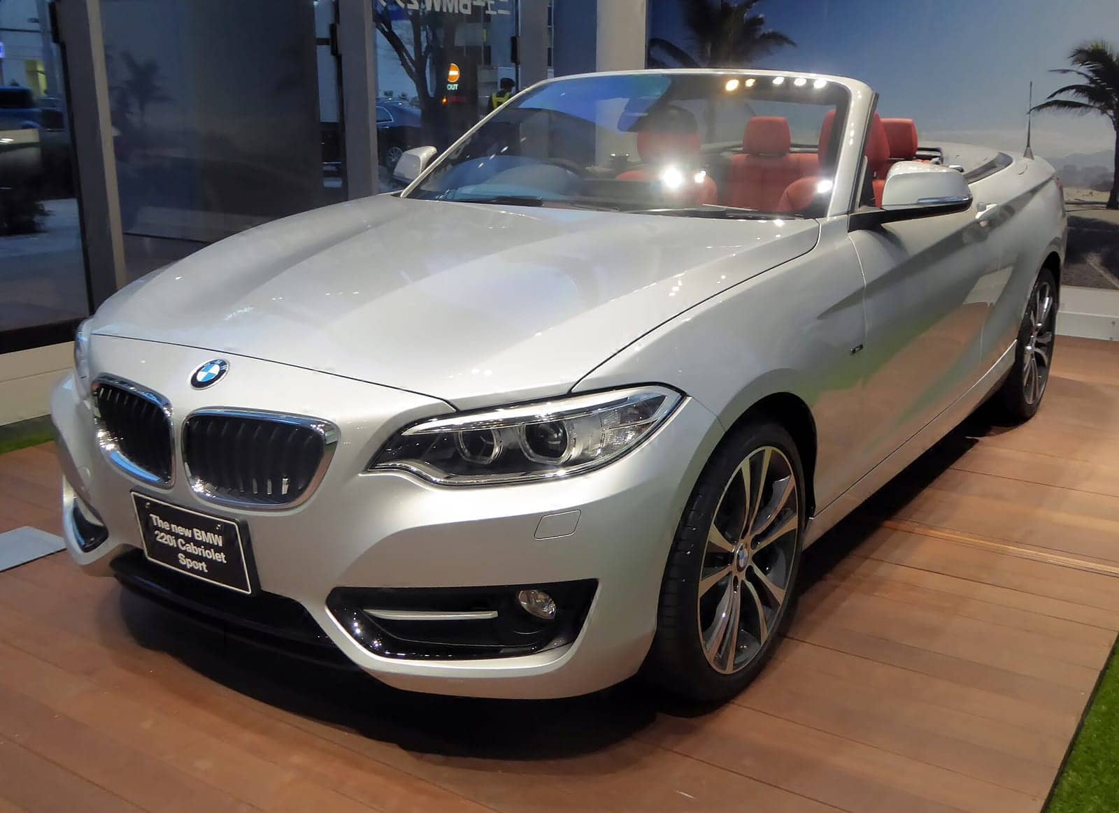Silver BMW 220i Sport convertible in a showroom, front three-quarter view