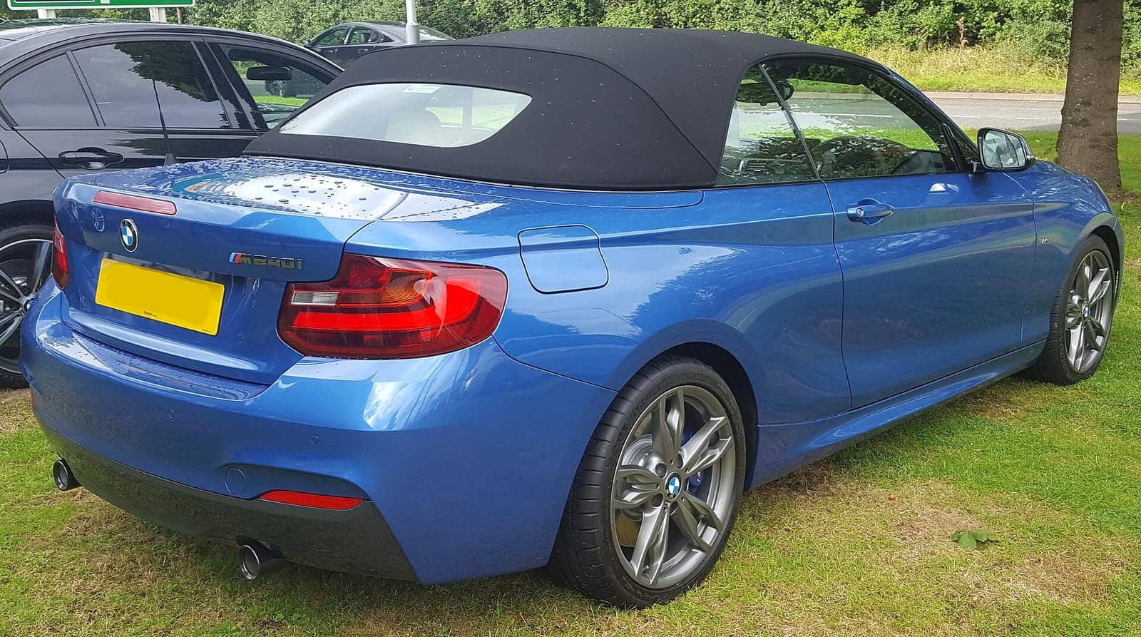 Blue BMW M240i convertible, rear three-quarter view