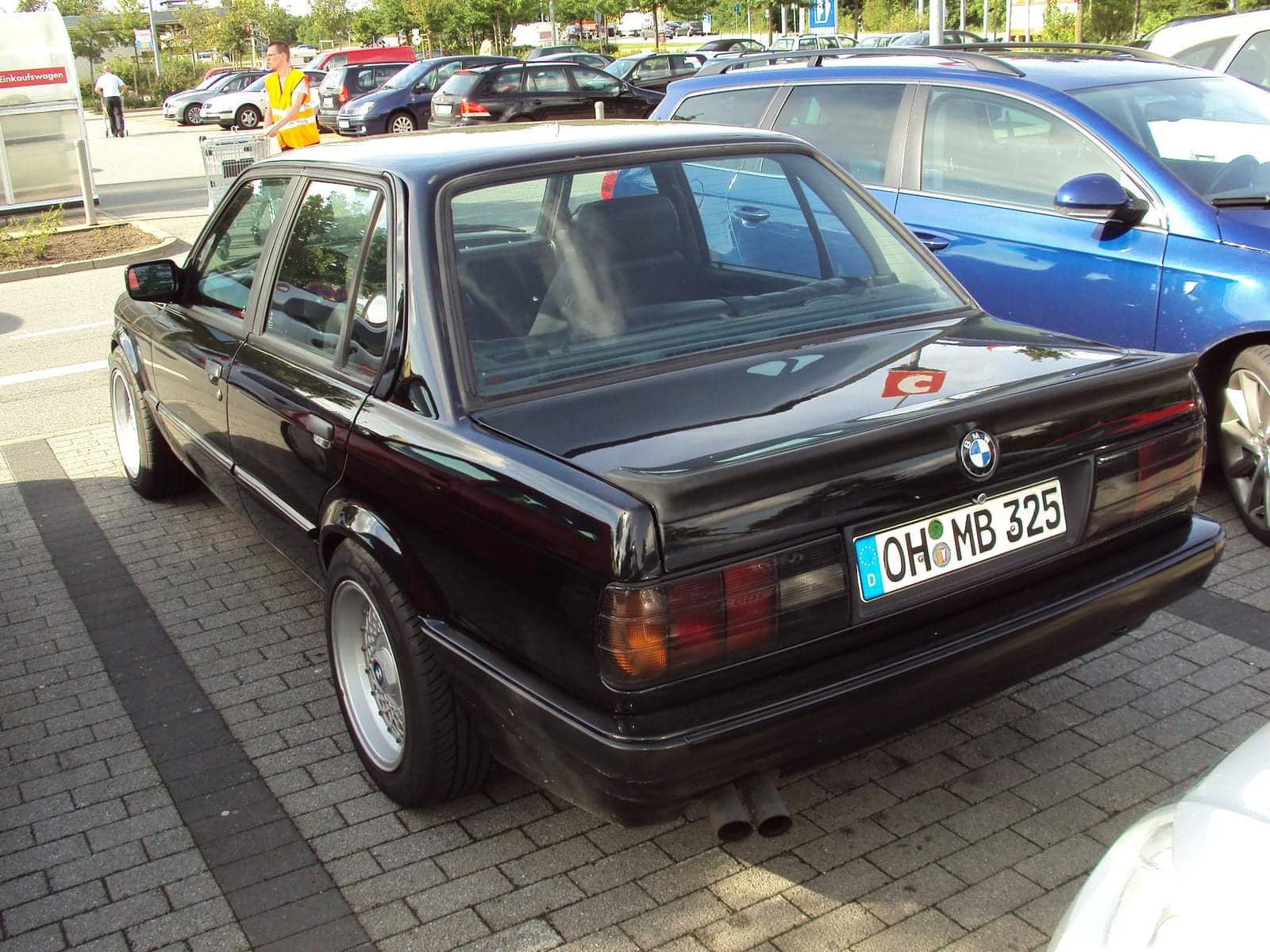Black BMW 325i four-door, rear three-quarter view