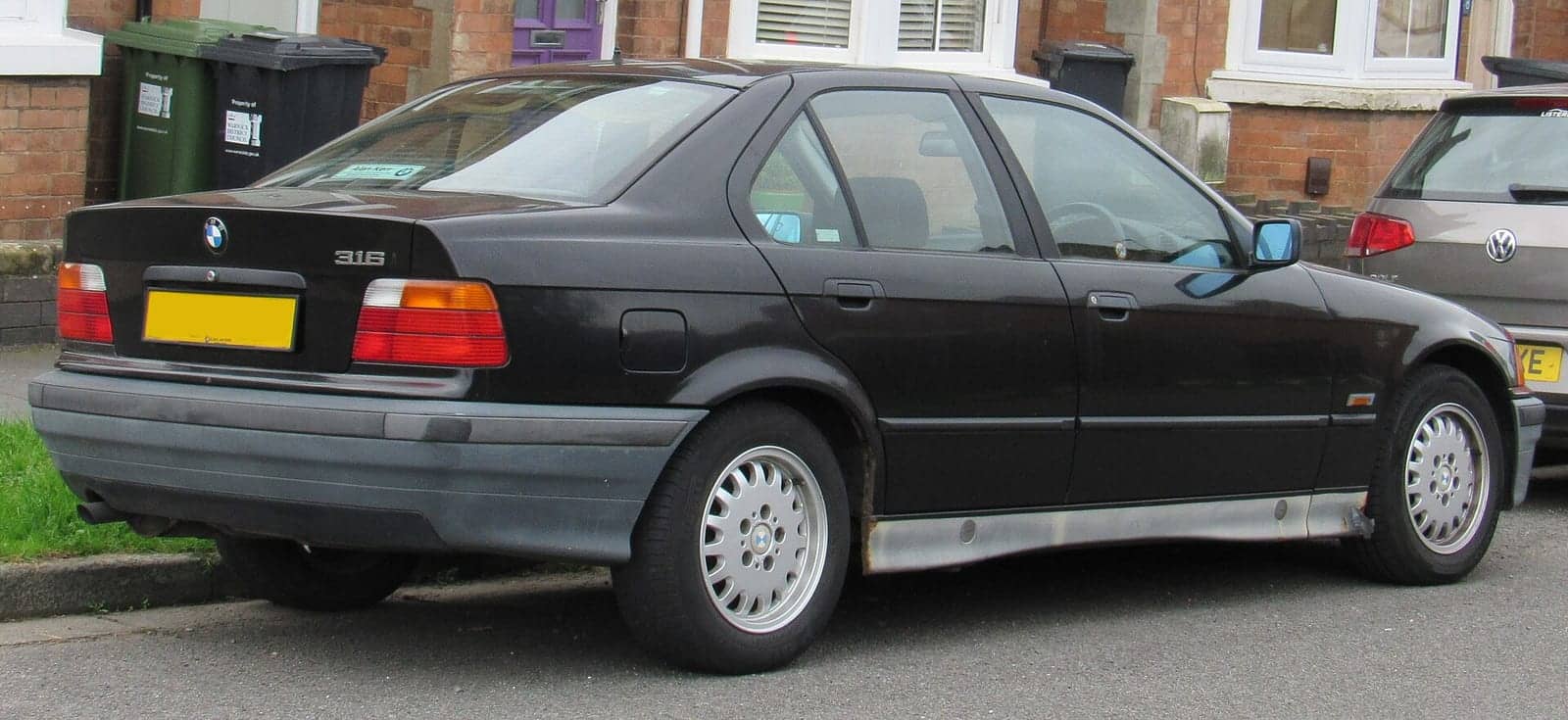 Black BMW 316i sedan, rear three-quarter view