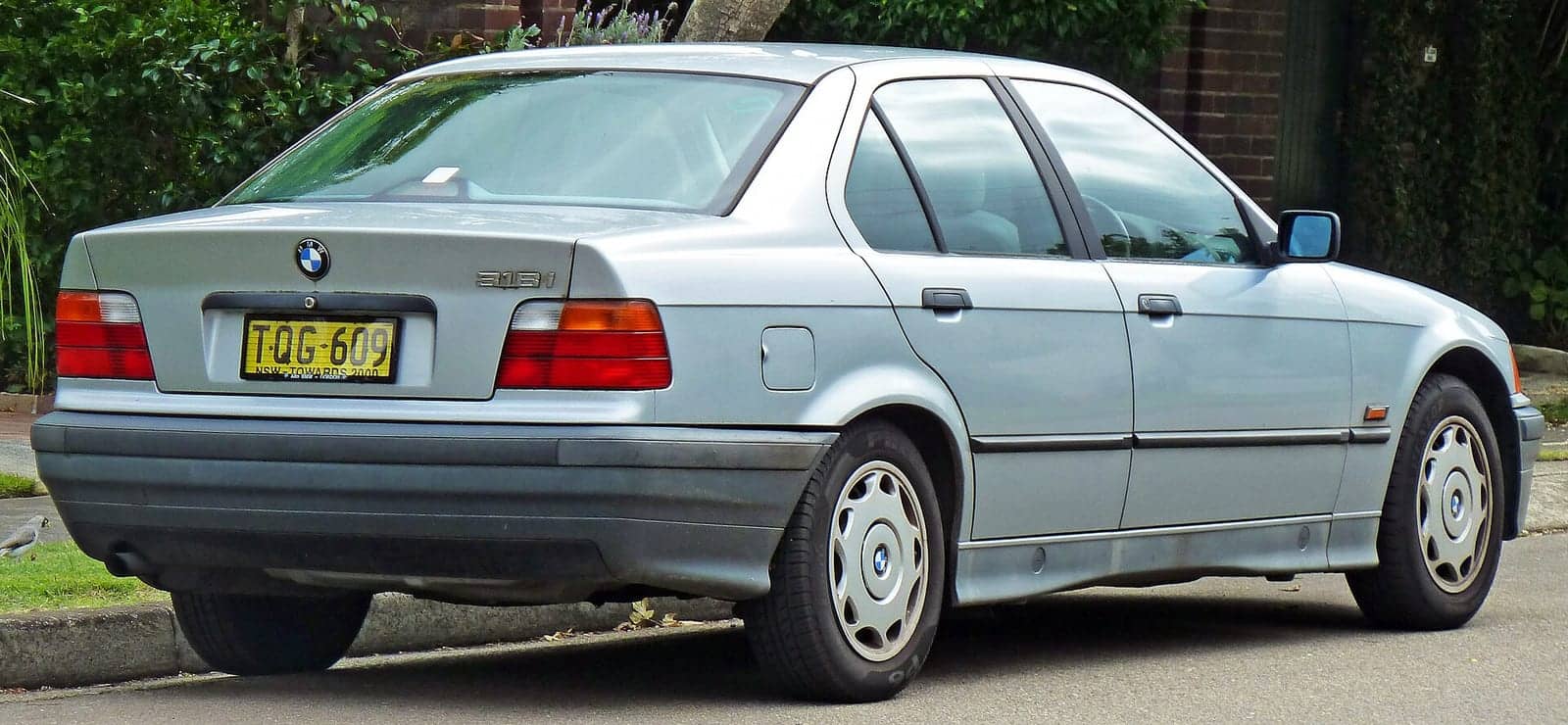 Silver BMW 318i sedan, rear three-quarter view