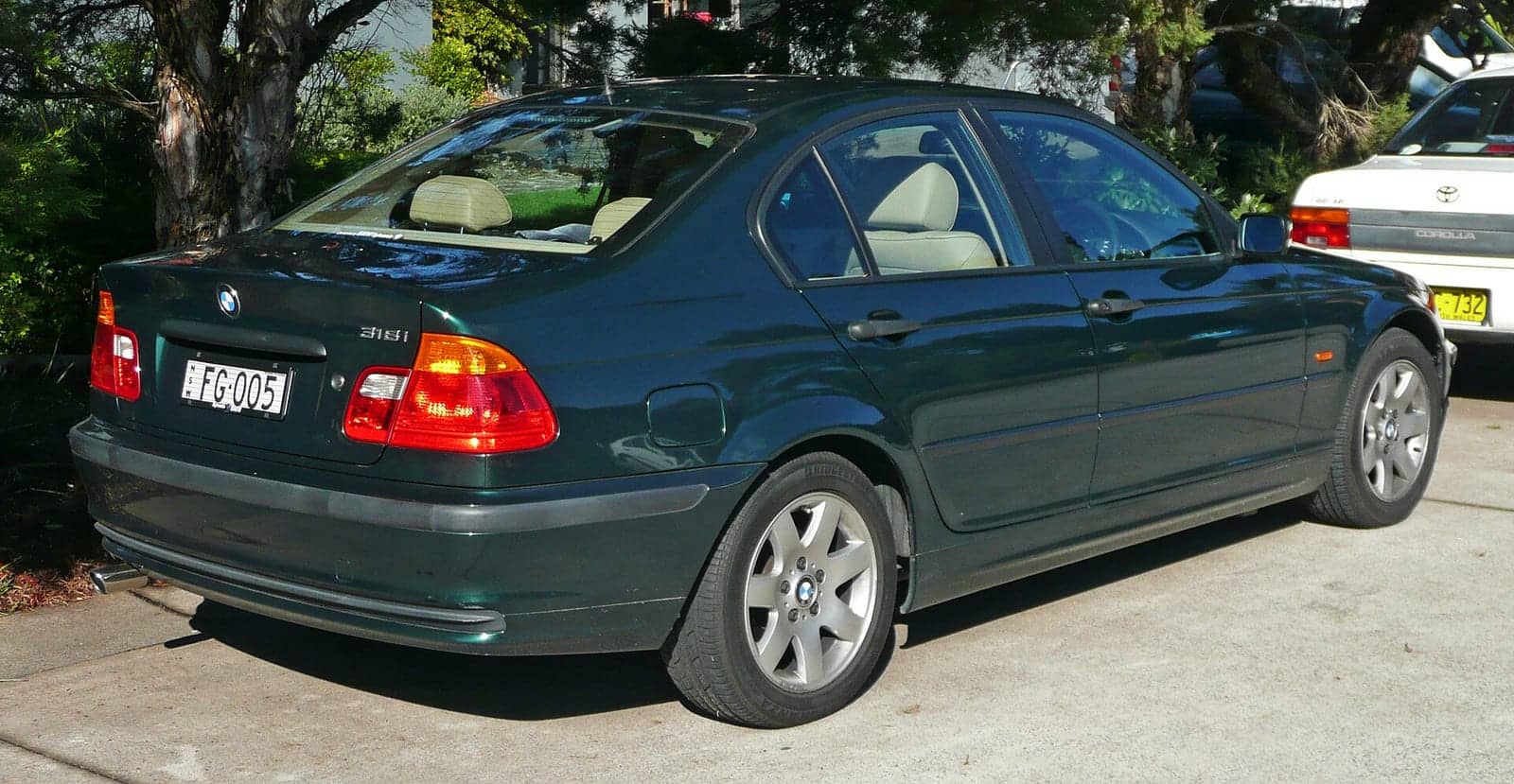 Dark green BMW 318i sedan, rear three-quarter view