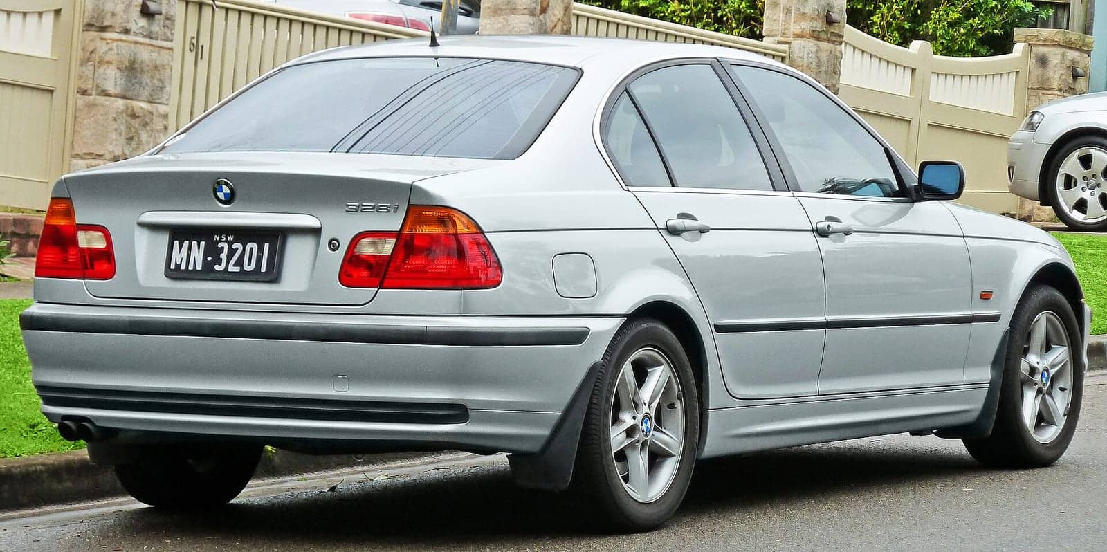 Silver BMW 328i sedan, rear three-quarter view