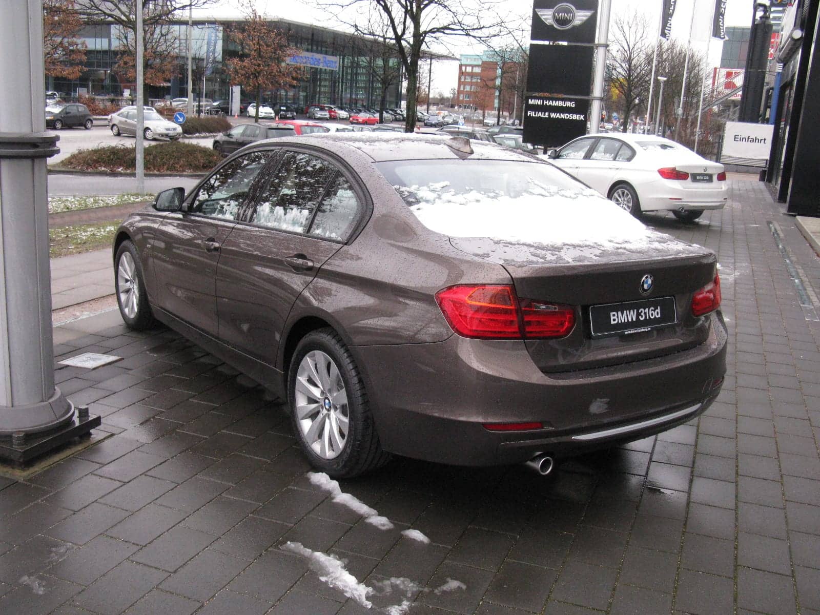 Brown BMW 316d sedan, rear three-quarter view