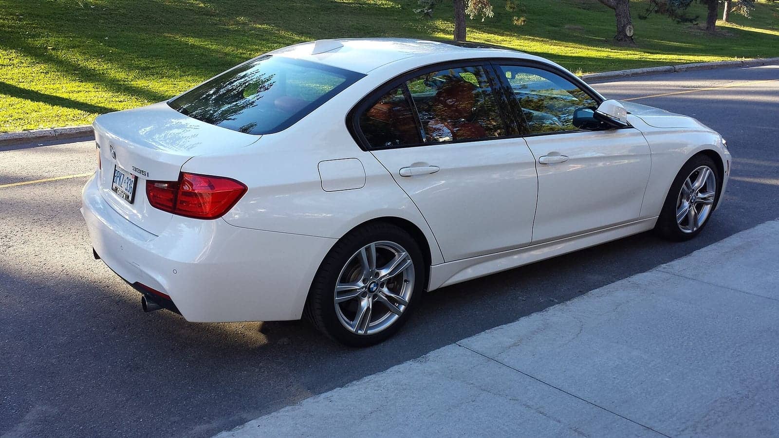 White BMW 335i xDrive sedan, rear three-quarter view