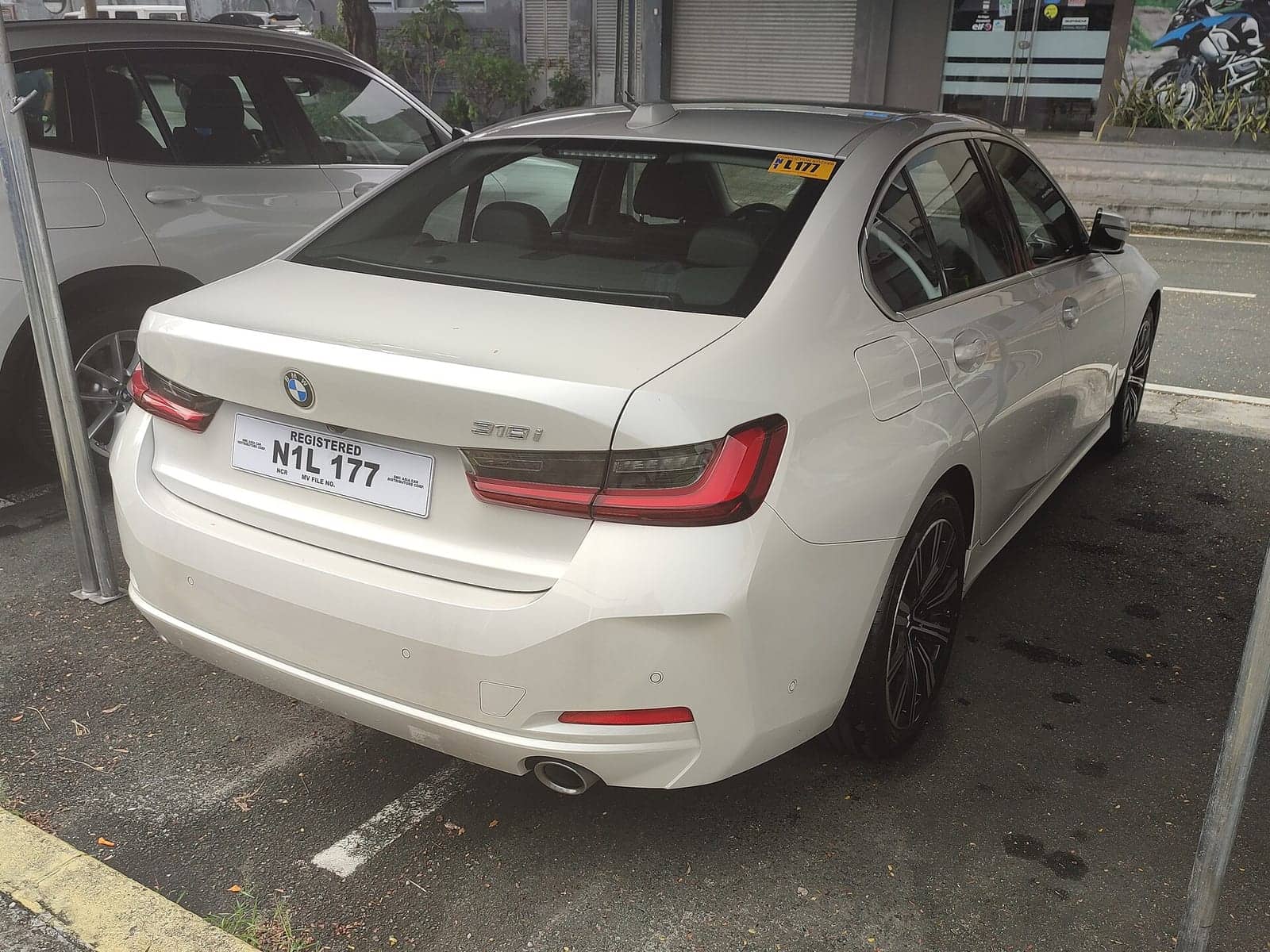 White BMW 318i sedan, rear three-quarter view