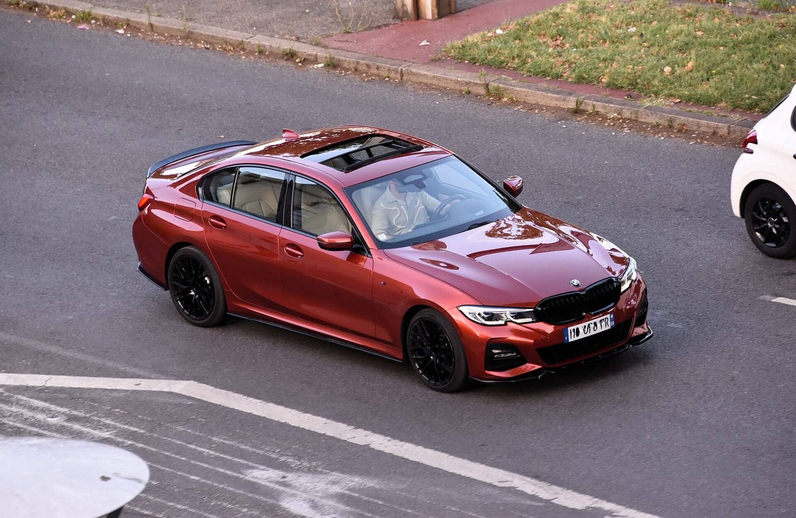 Red BMW M340i xDrive sedan seen from above, front three-quarter view
