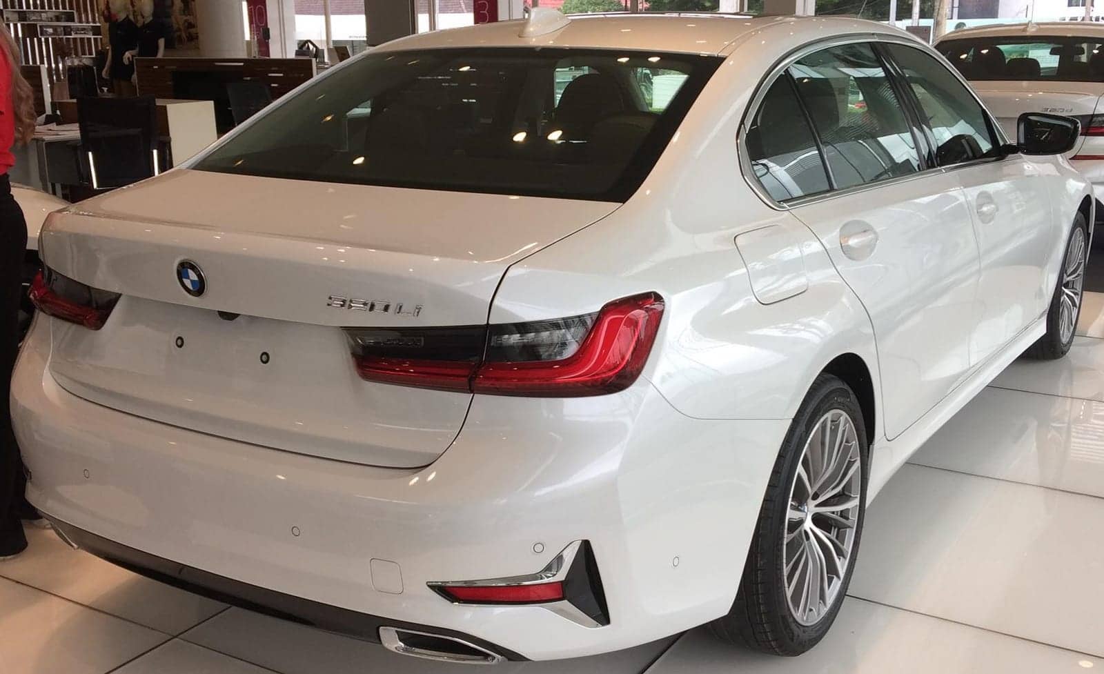 White BMW 320Li Luxury in a showroom, rear three-quarter view