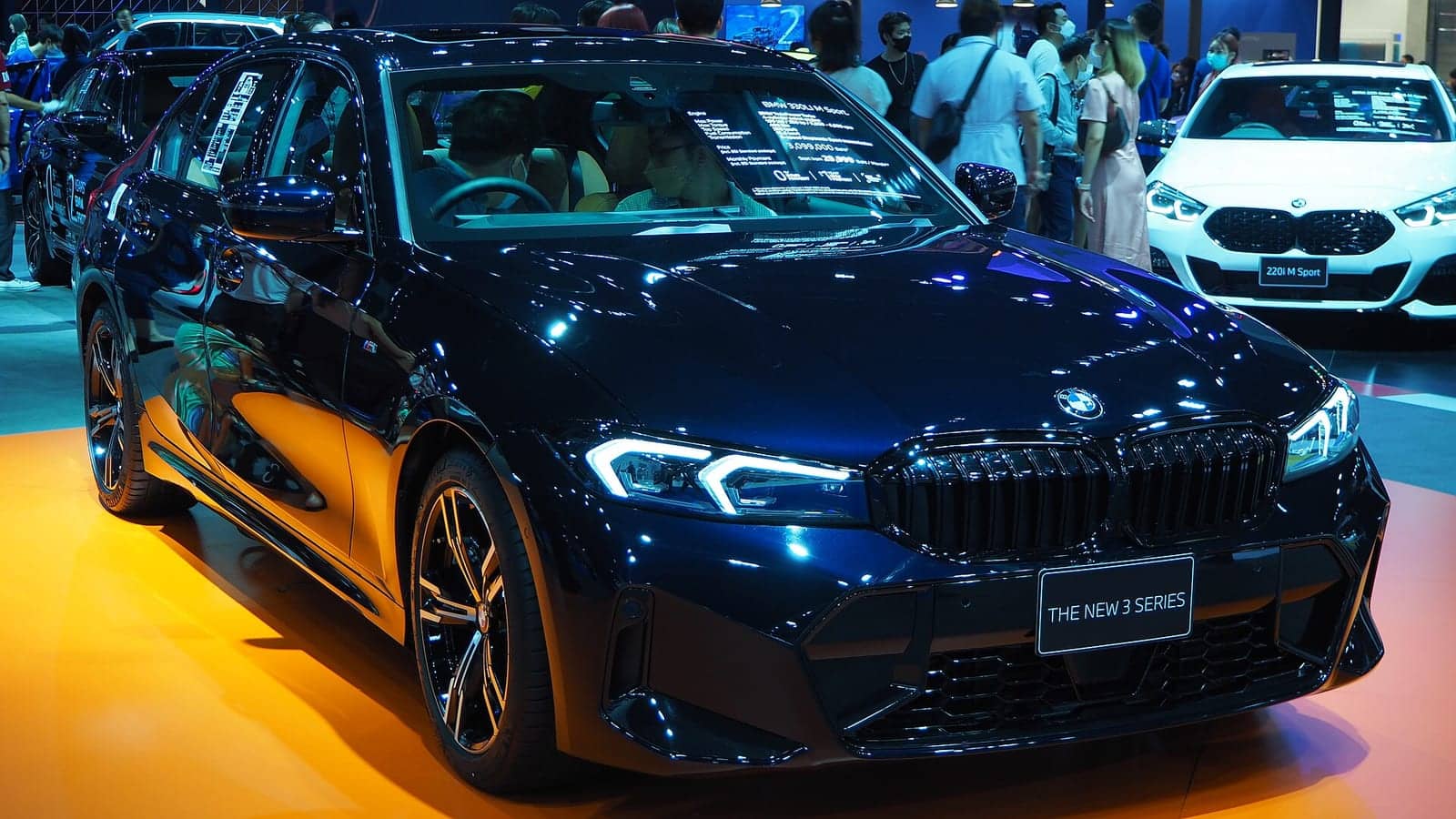 Dark blue BMW 330Li M Sport (facelift) at a motor show, front three-quarter view