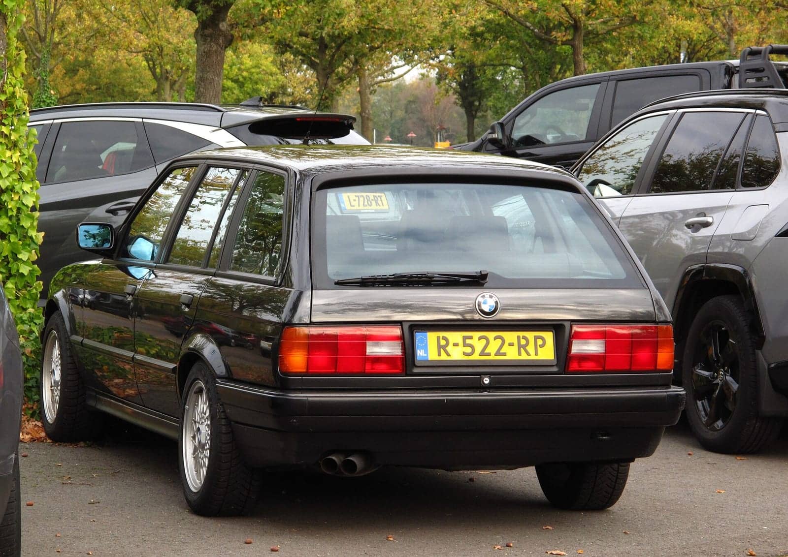 Black BMW 325i Touring, rear three-quarter view