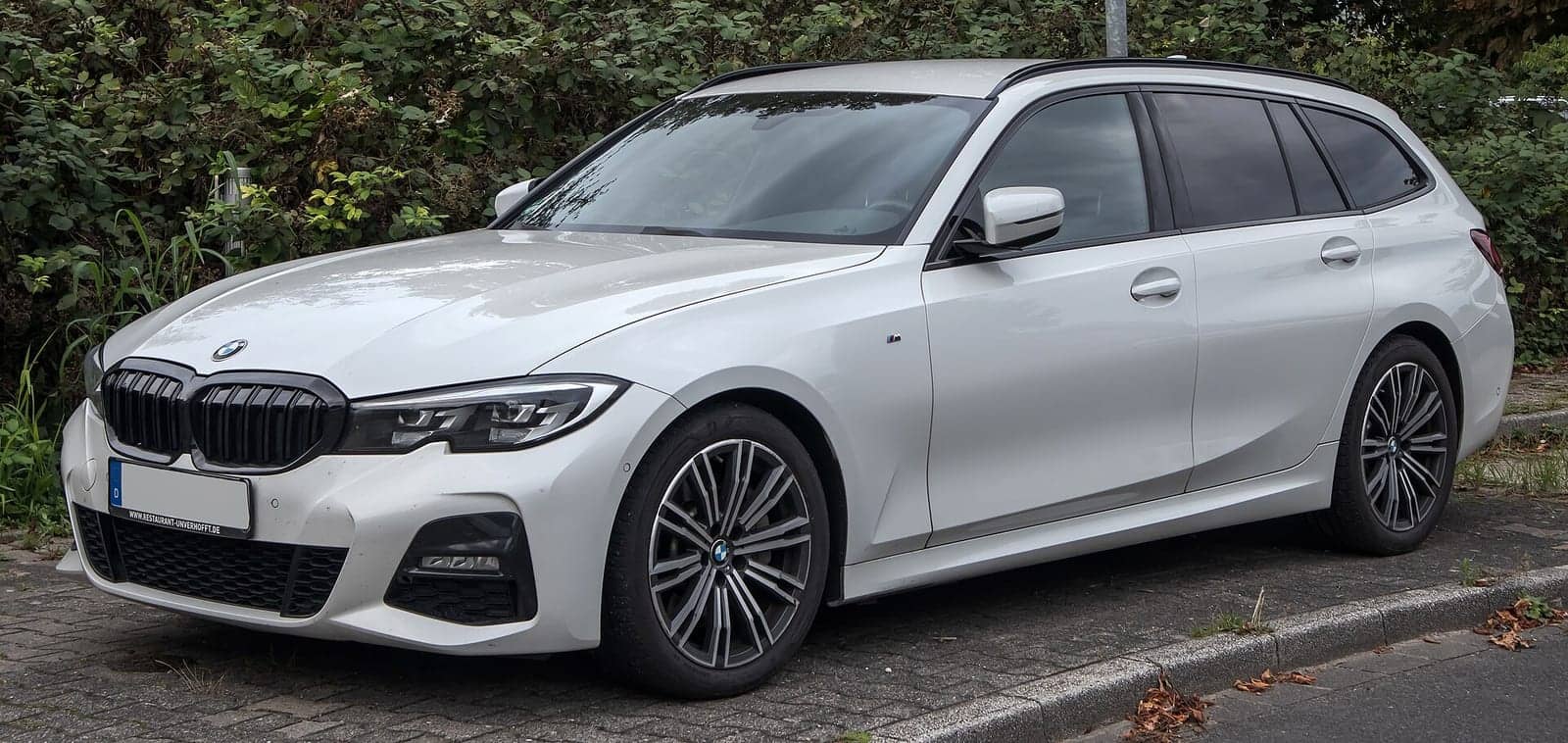 White BMW 330i Touring M Sport, front three-quarter view
