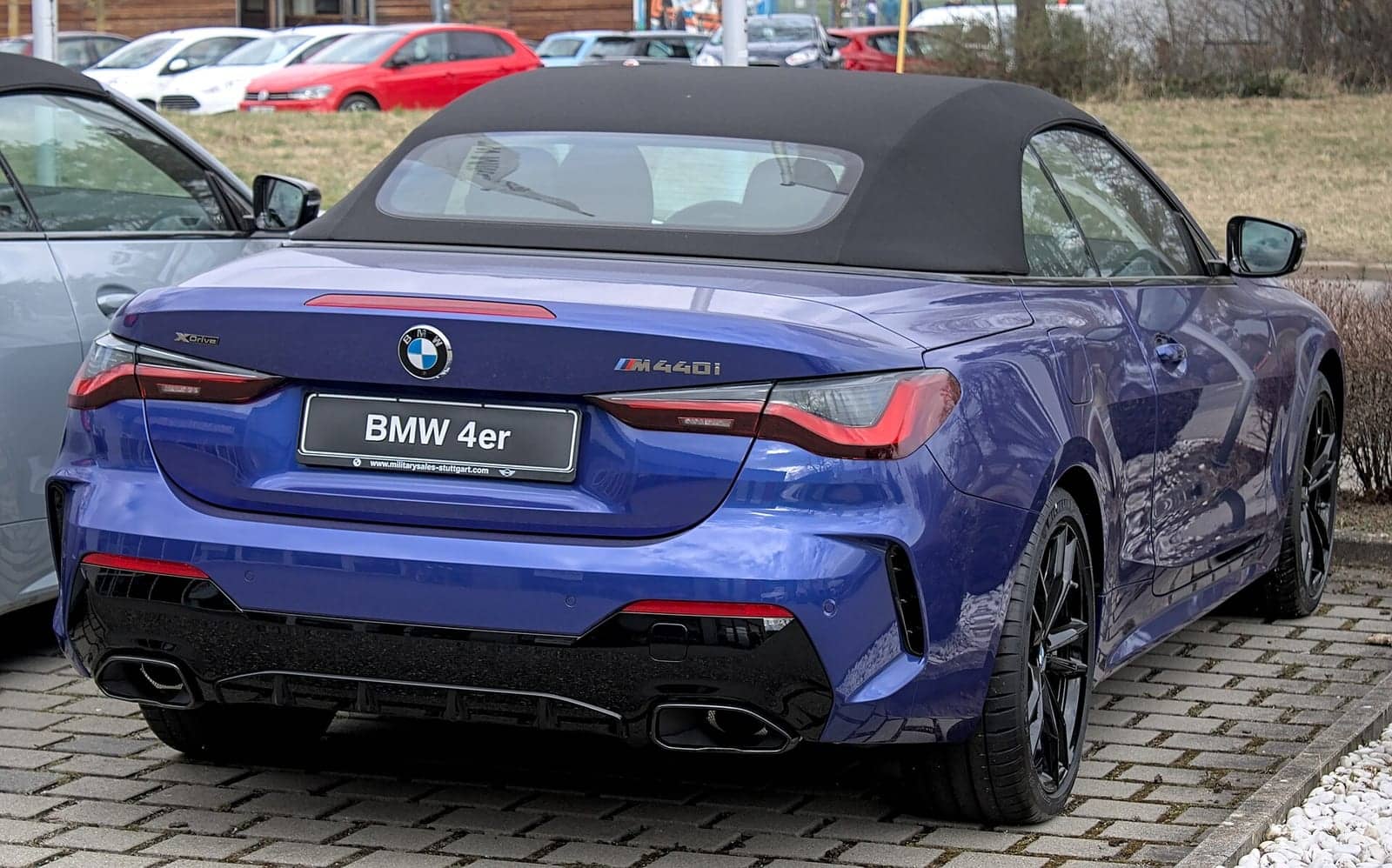 Blue BMW M440i convertible, rear three-quarter view
