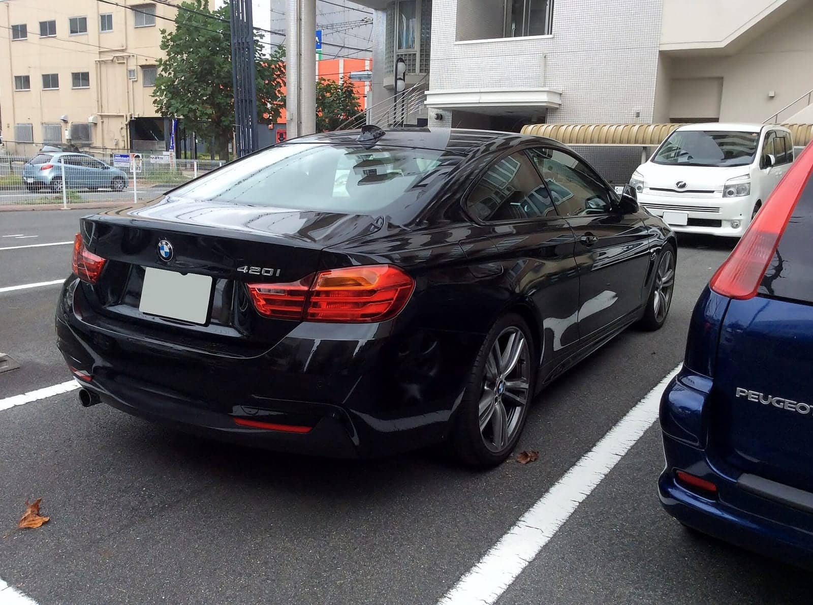 Black BMW 420i M Sport coupé, rear three-quarter view