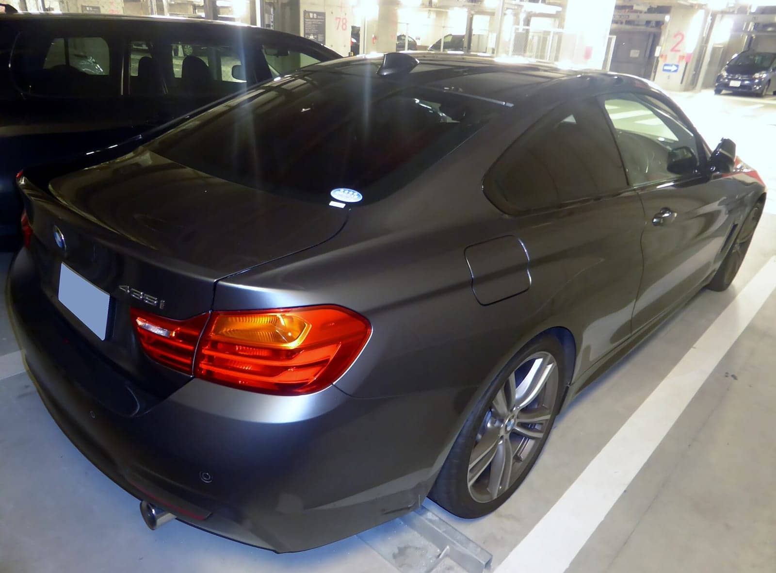 Black BMW 435i Sport coupé, rear three-quarter view