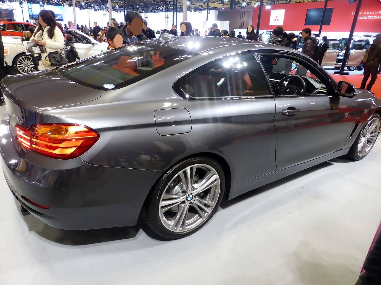 Grey BMW 435i Sport coupé at a motor show, rear three-quarter view