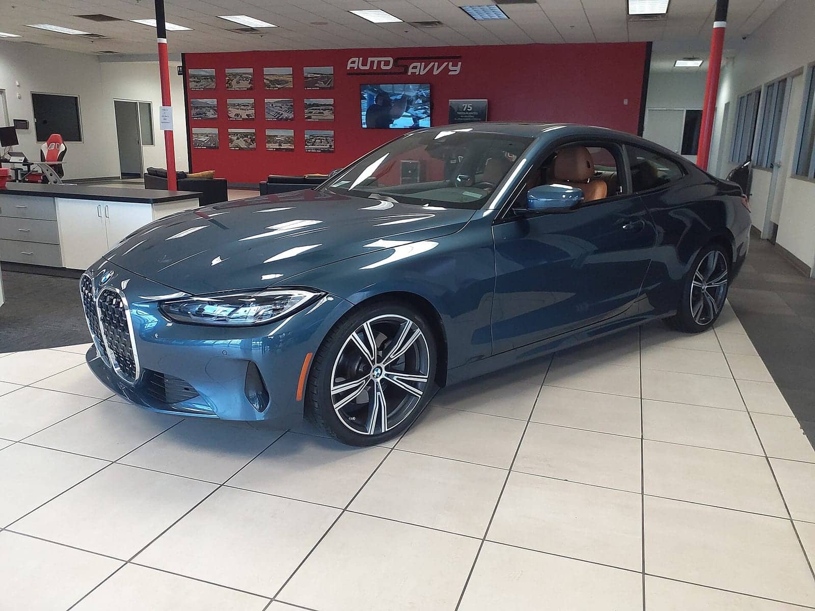 Blue BMW 430i coupé in a showroom, front three-quarter view