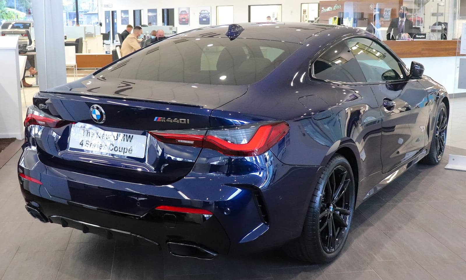 Blue BMW M440i xDrive coupé, rear three-quarter view
