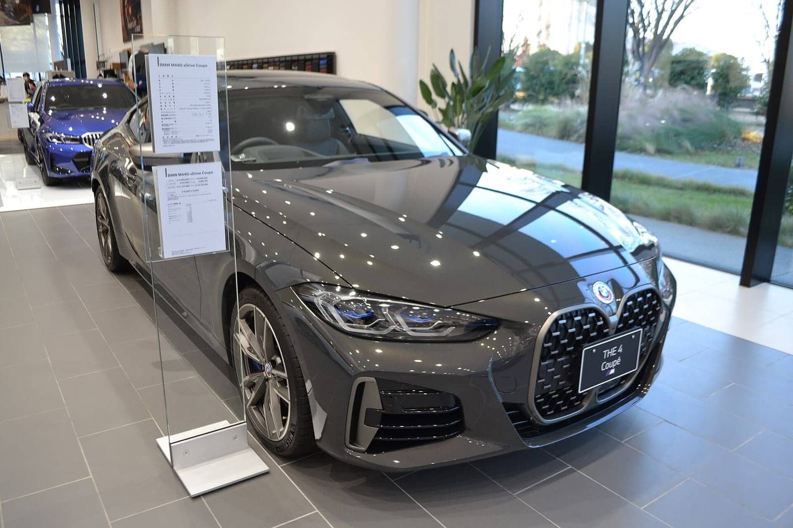 Grey BMW M440i xDrive coupé in a showroom, front three-quarter view