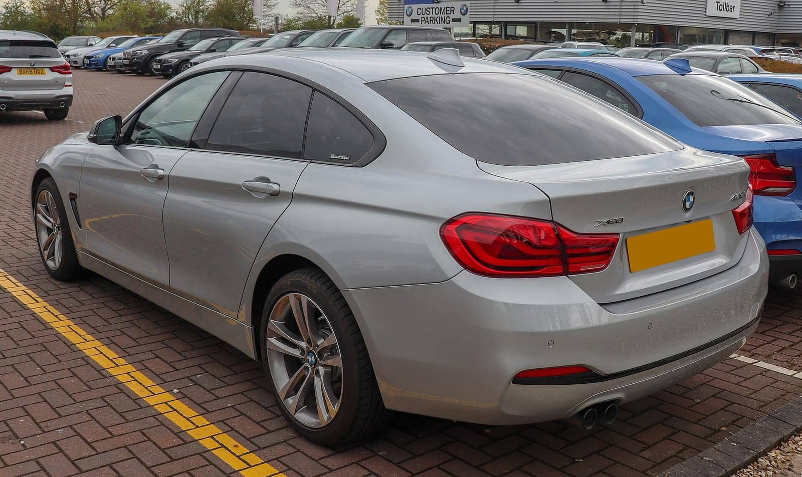 Silver BMW 420i xDrive Gran Coupé Sport (facelift), rear three-quarter view