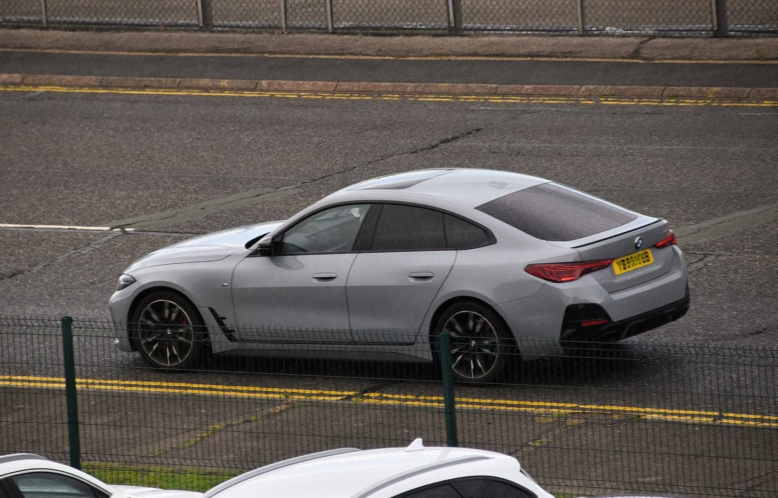 Silver BMW M440i xDrive Gran Coupé (facelift), rear three-quarter view