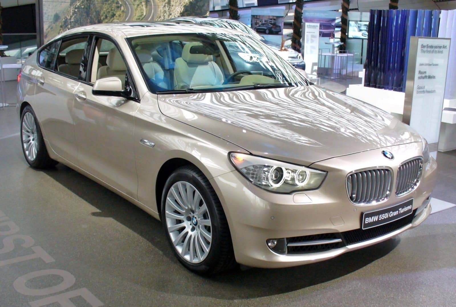 Silver BMW 550i Gran Turismo in a showroom, front three-quarter view