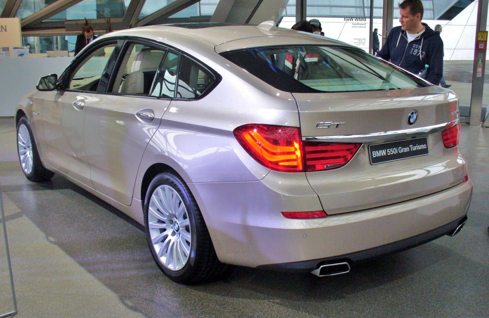 Silver BMW 550i Gran Turismo in a showroom, rear three-quarter view