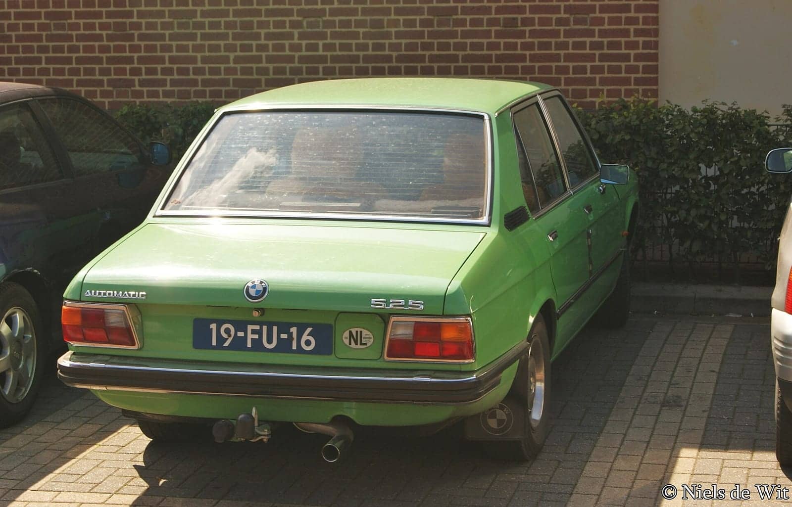 Green BMW 525, rear three-quarter view