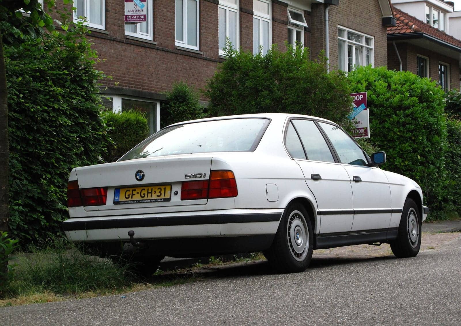 White BMW 518i, rear three-quarter view