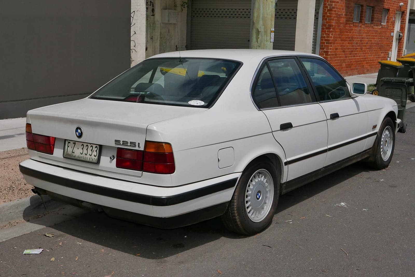 White BMW 525i, rear three-quarter view