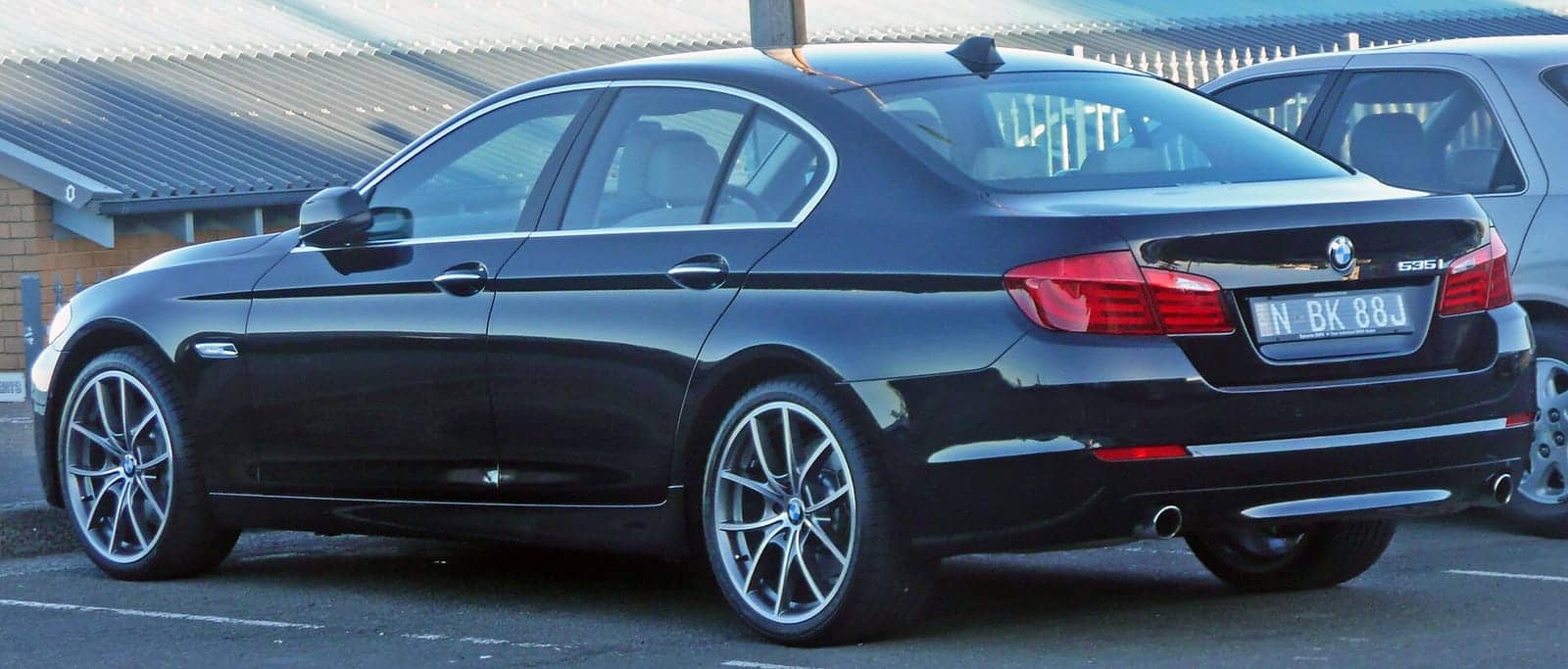 Black BMW 535i, rear three-quarter view