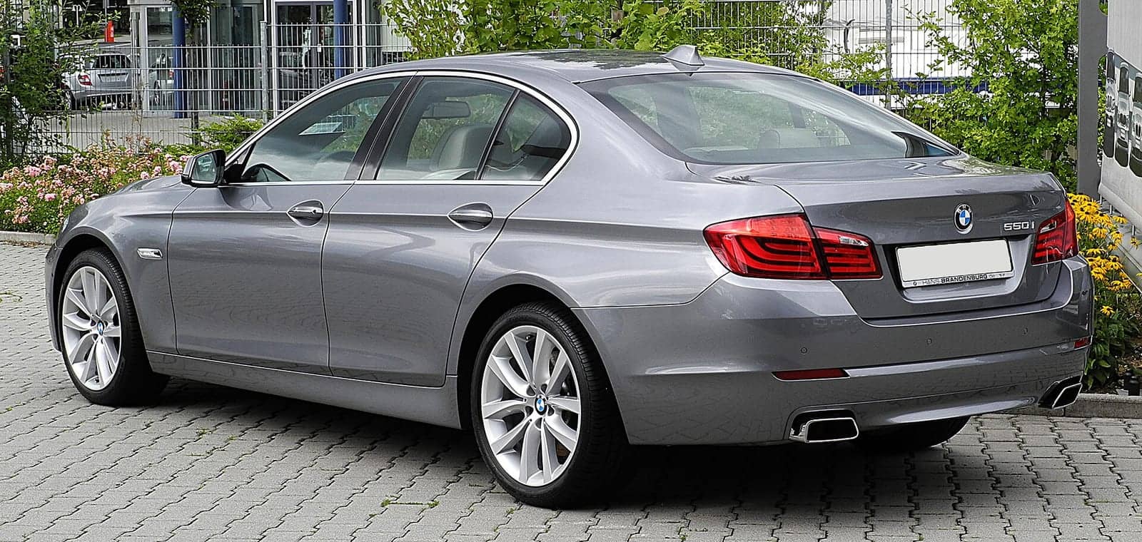 Grey BMW 550i, rear three-quarter view