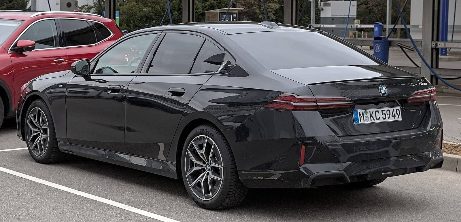 Black BMW 520i, rear three-quarter view
