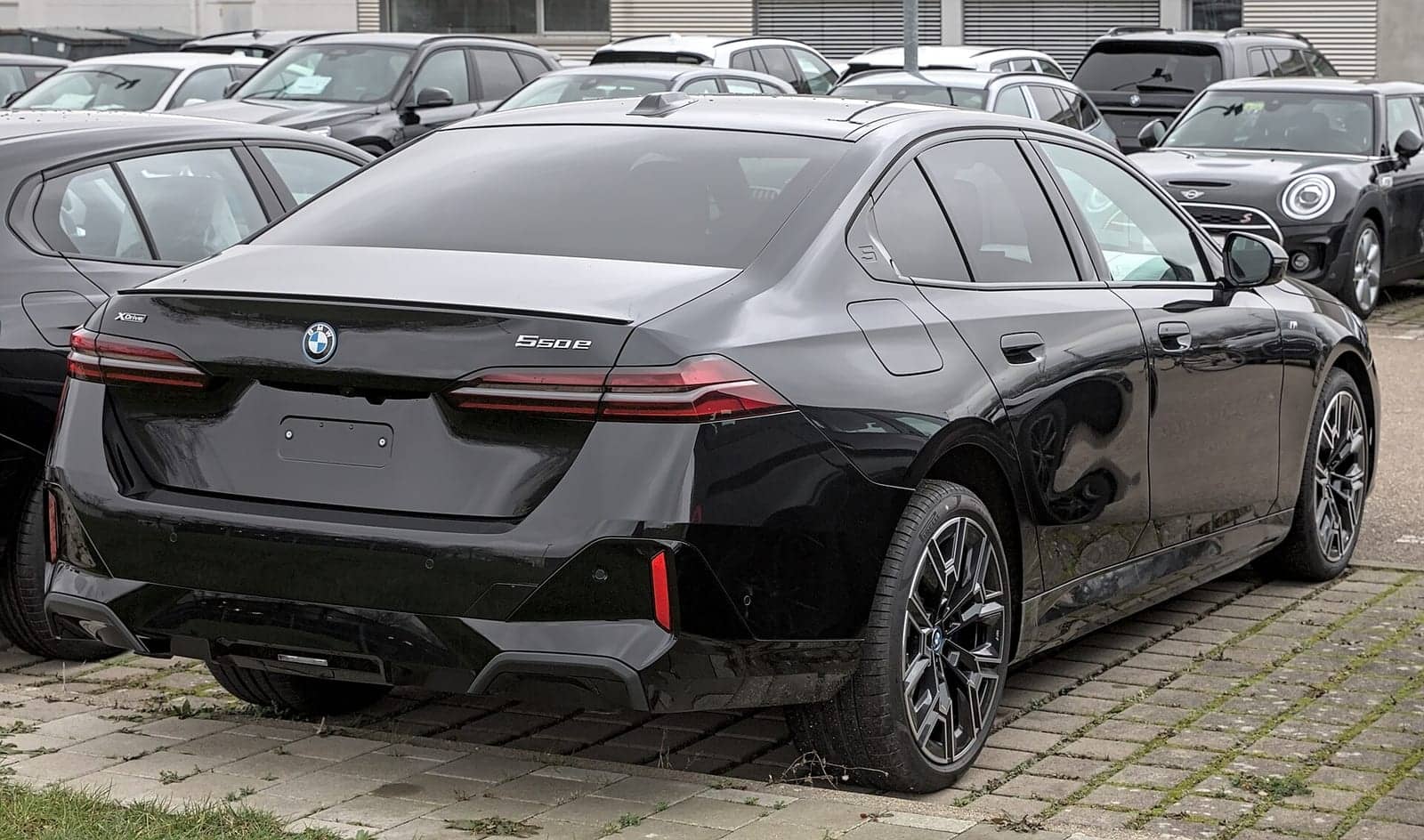Black BMW 550e xDrive, rear three-quarter view