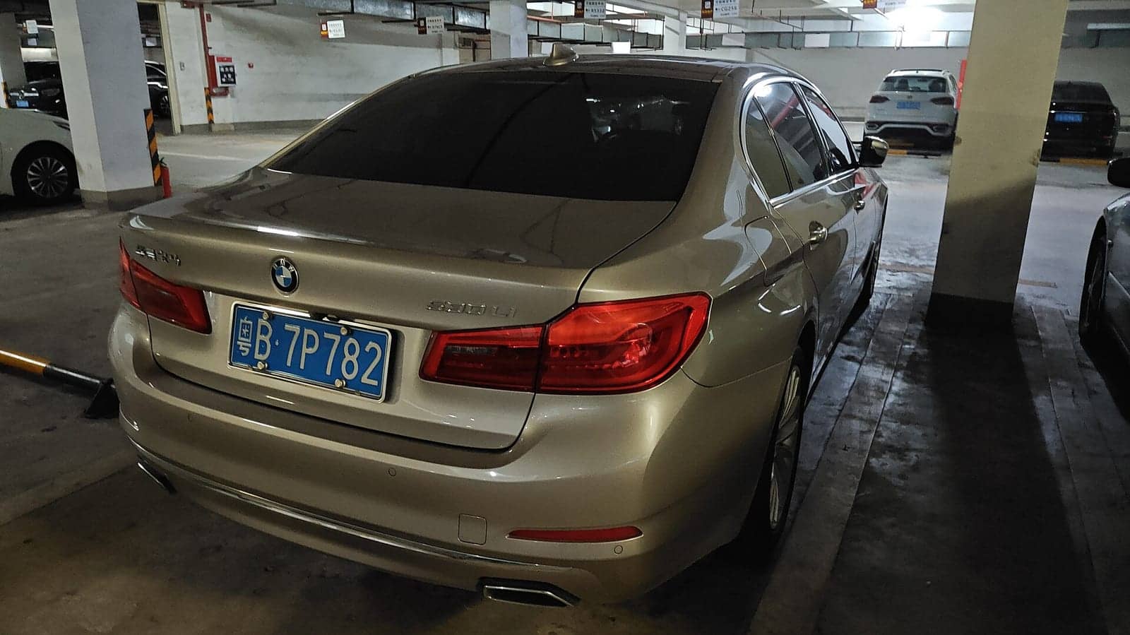Gold BMW 530Li, rear three-quarter view