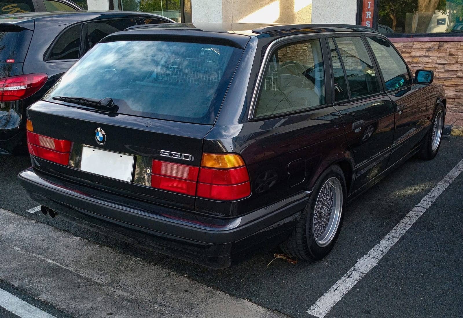 Black BMW 530i Touring, rear three-quarter view