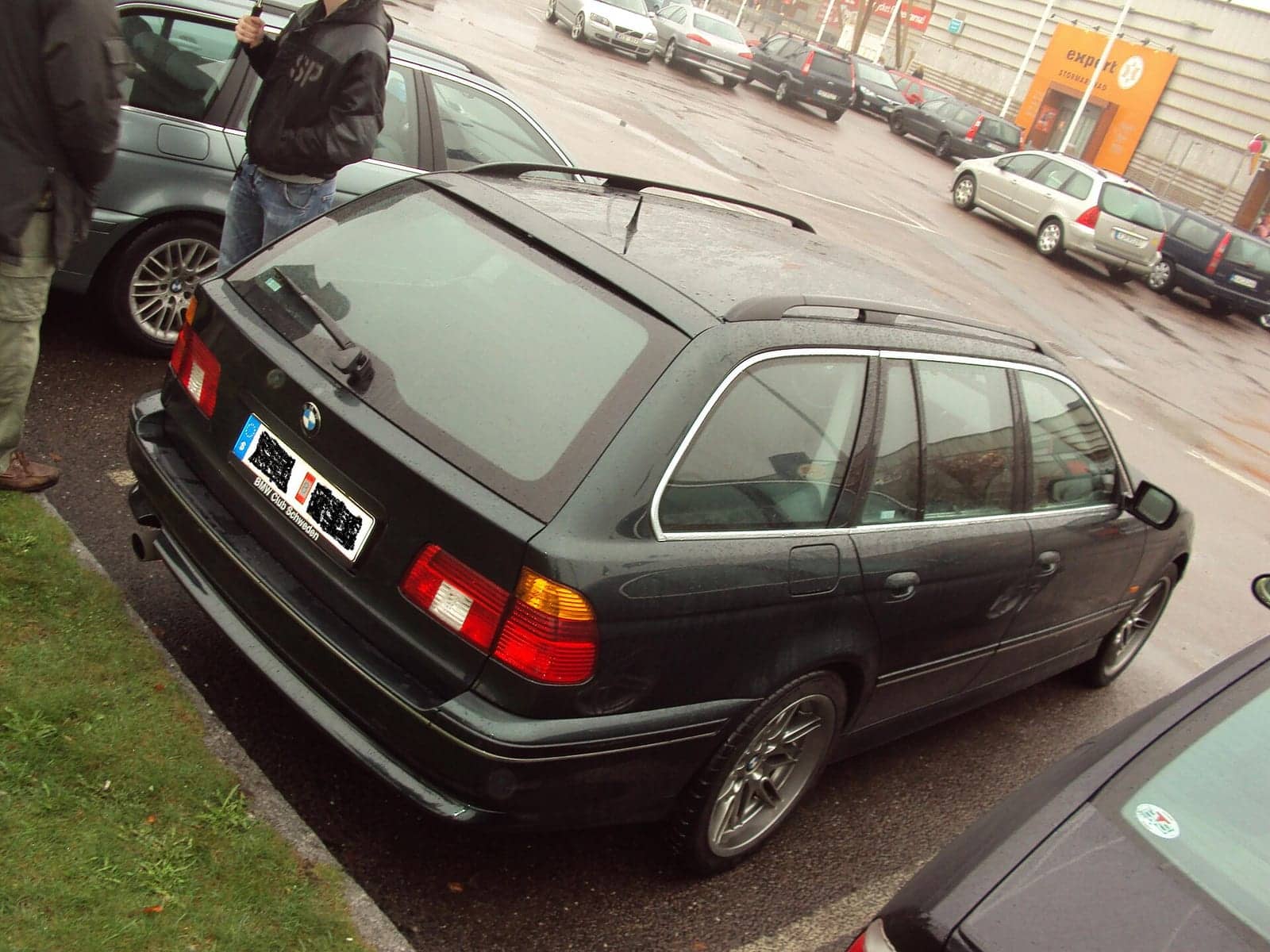 Dark green BMW 540i Touring, rear three-quarter view