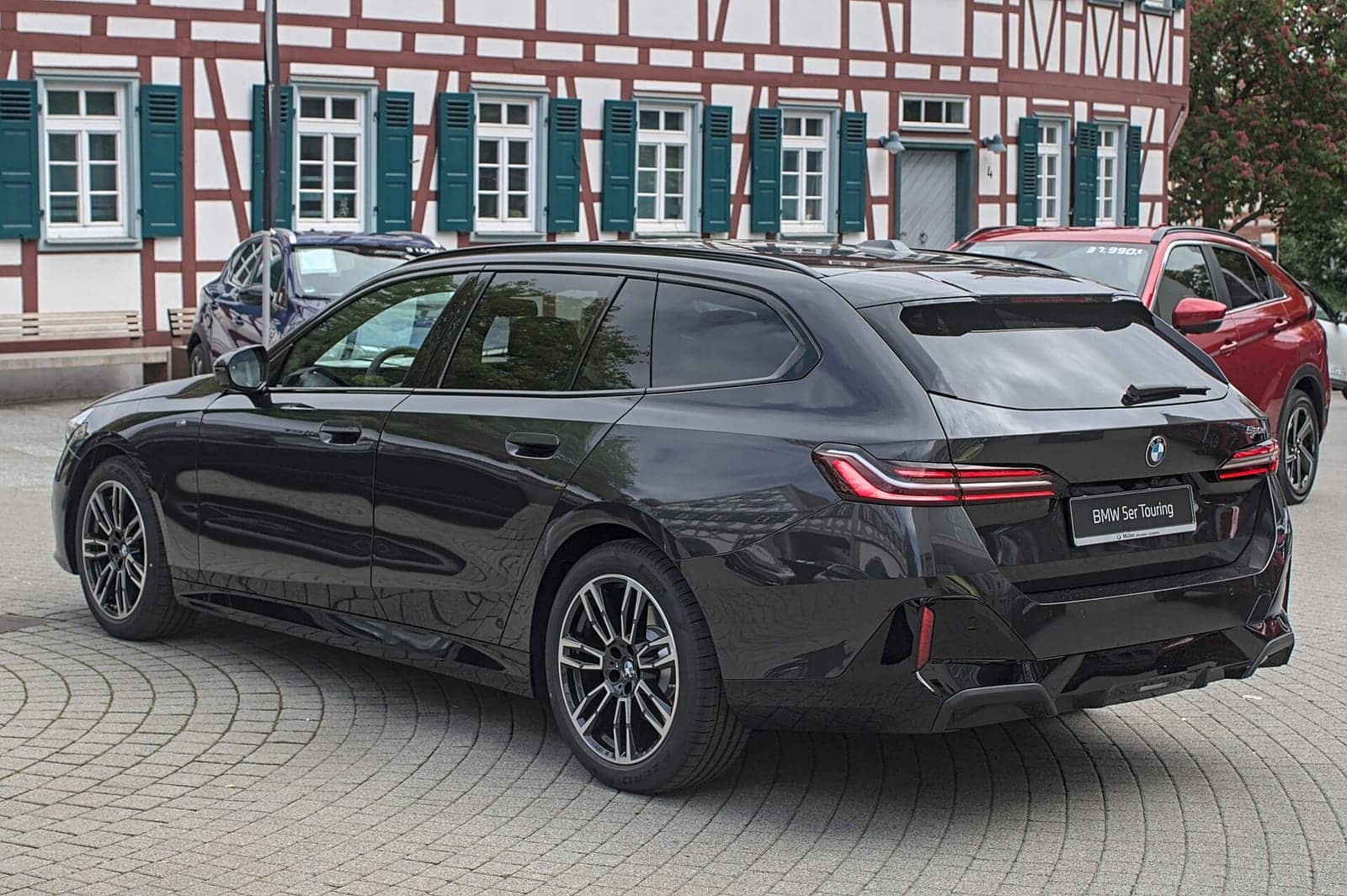 Black BMW 520d Touring, rear three-quarter view