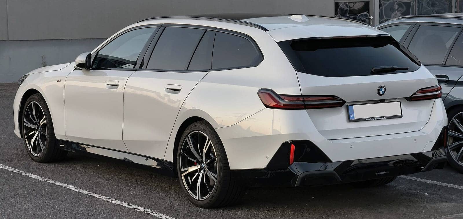 White BMW 5 Series Touring M Sport, rear three-quarter view