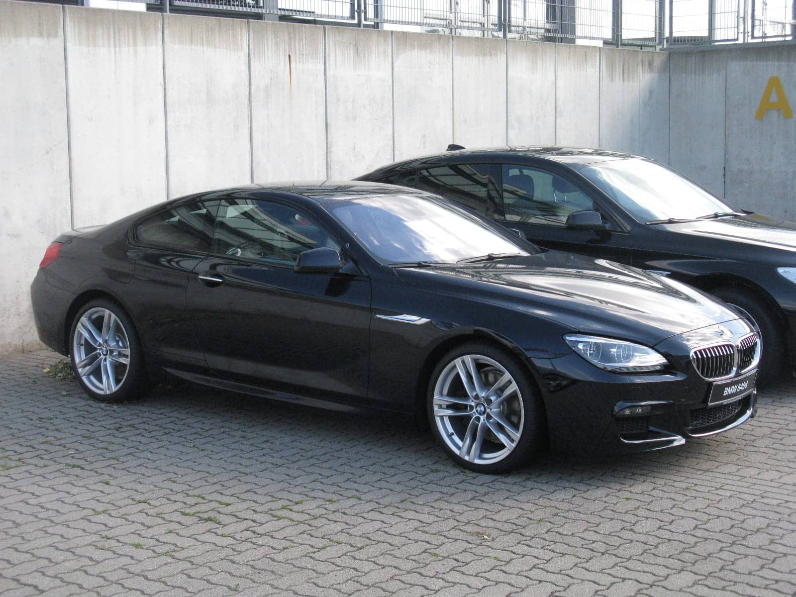 Black BMW 640d M Sport coupé, side view