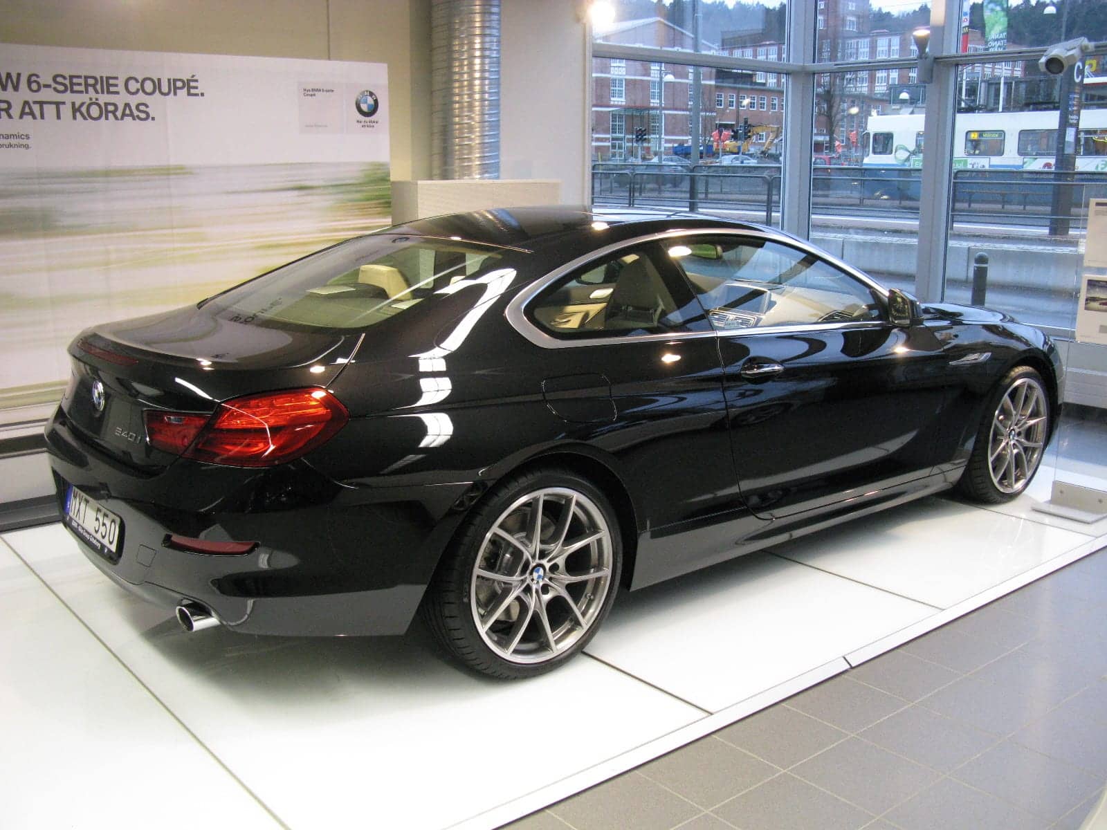 Black BMW 640i coupé in a showroom, rear three-quarter view