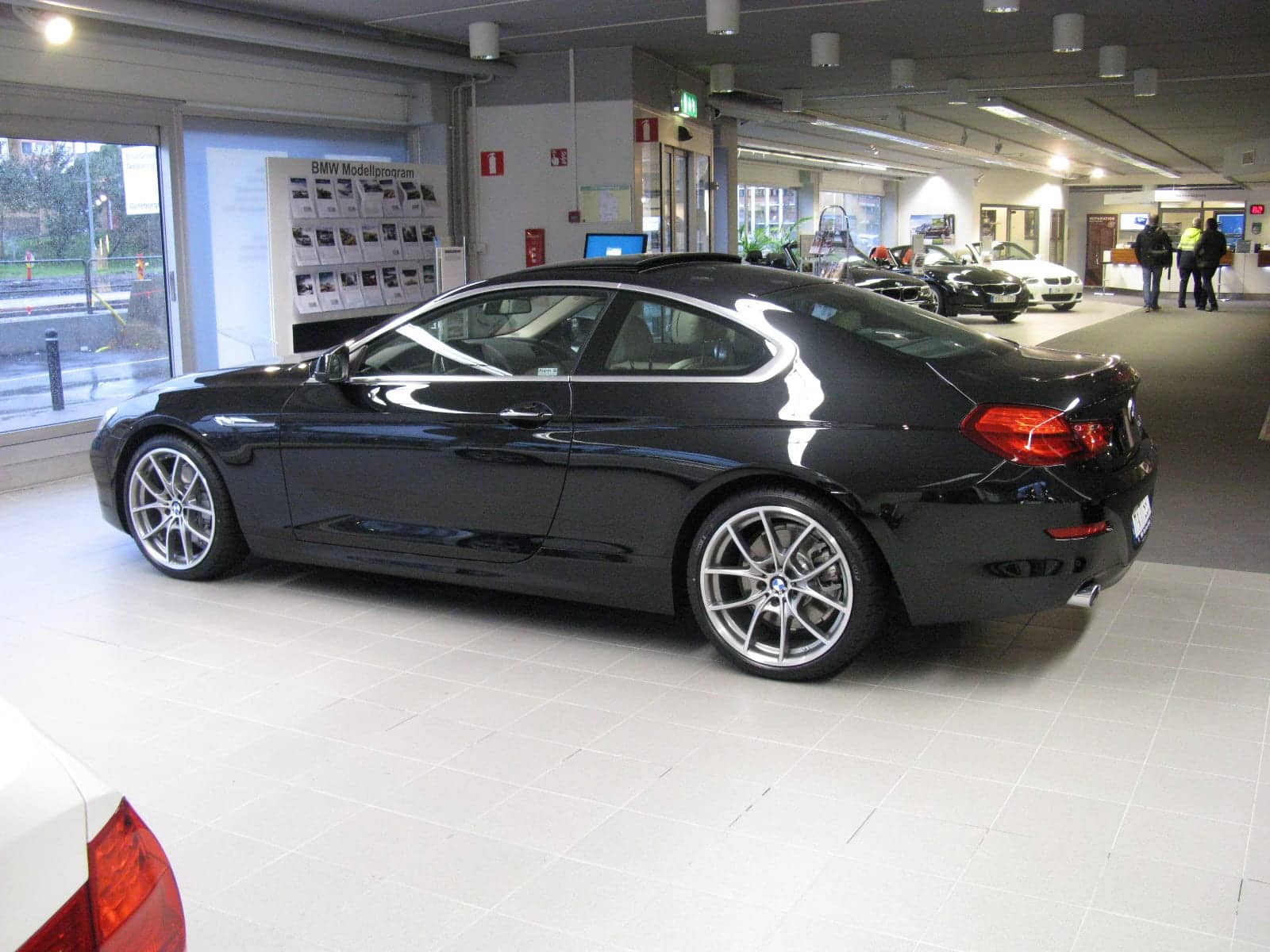 Black BMW 640i coupé in a showroom, side view