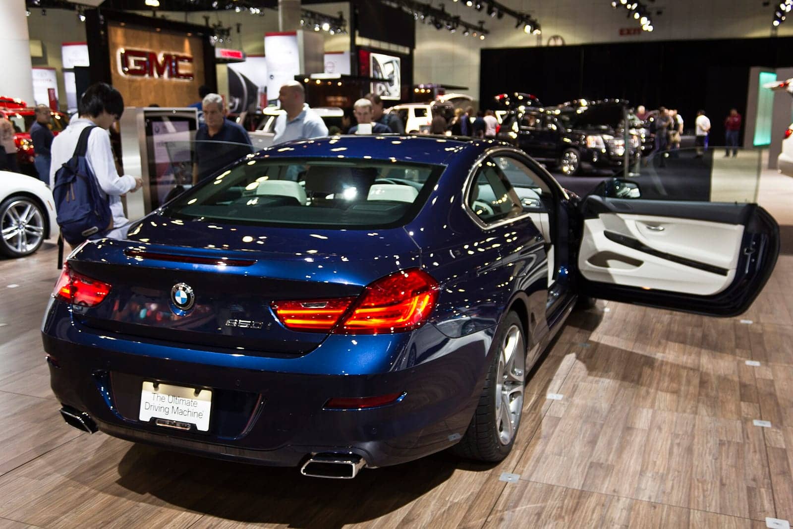Dark blue BMW 650i coupé at a motor show, rear three-quarter view
