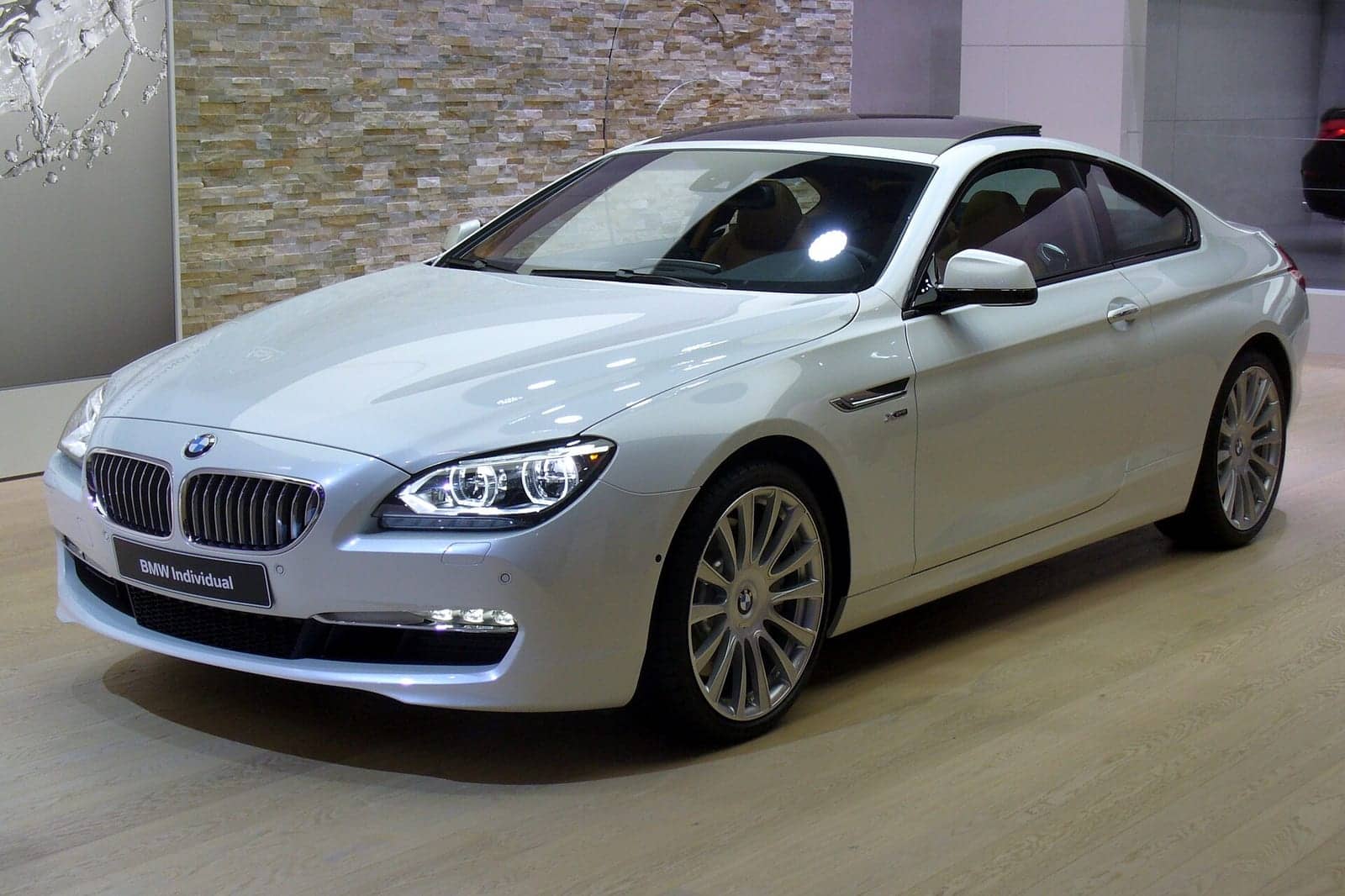 White BMW 650i xDrive Individual coupé at a motor show, front three-quarter view