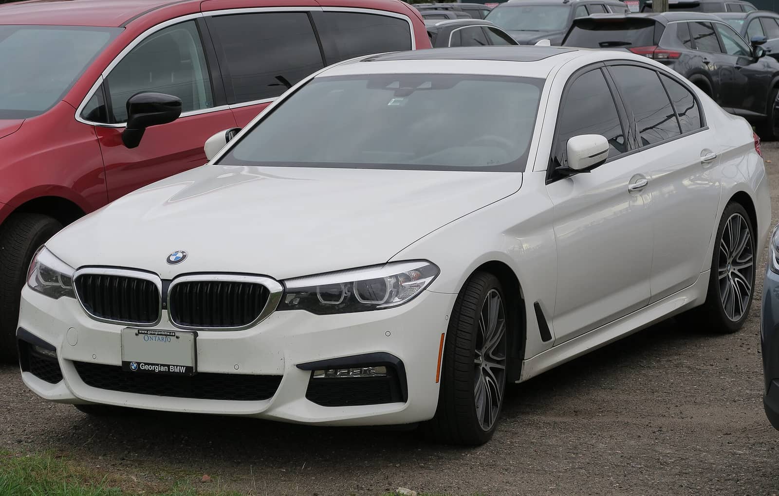 White BMW 540i xDrive with M Sport package, front three-quarter view