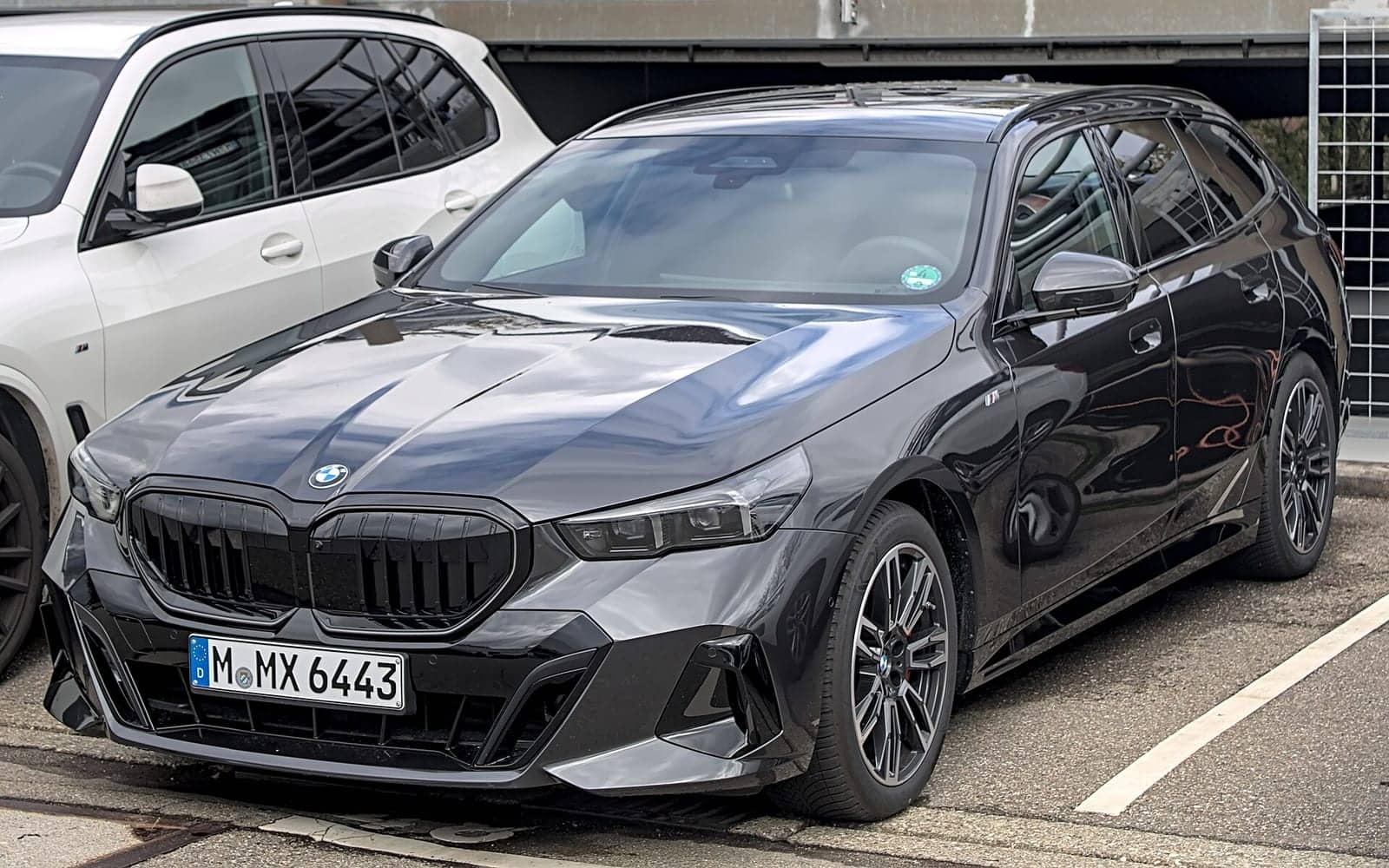 Black BMW 540d xDrive Touring, front three-quarter view